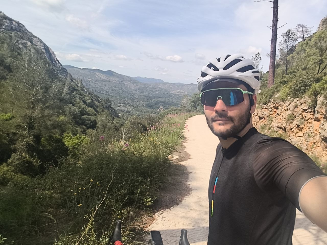 Out on a road ride, stopped on a climb with wooded hills behind